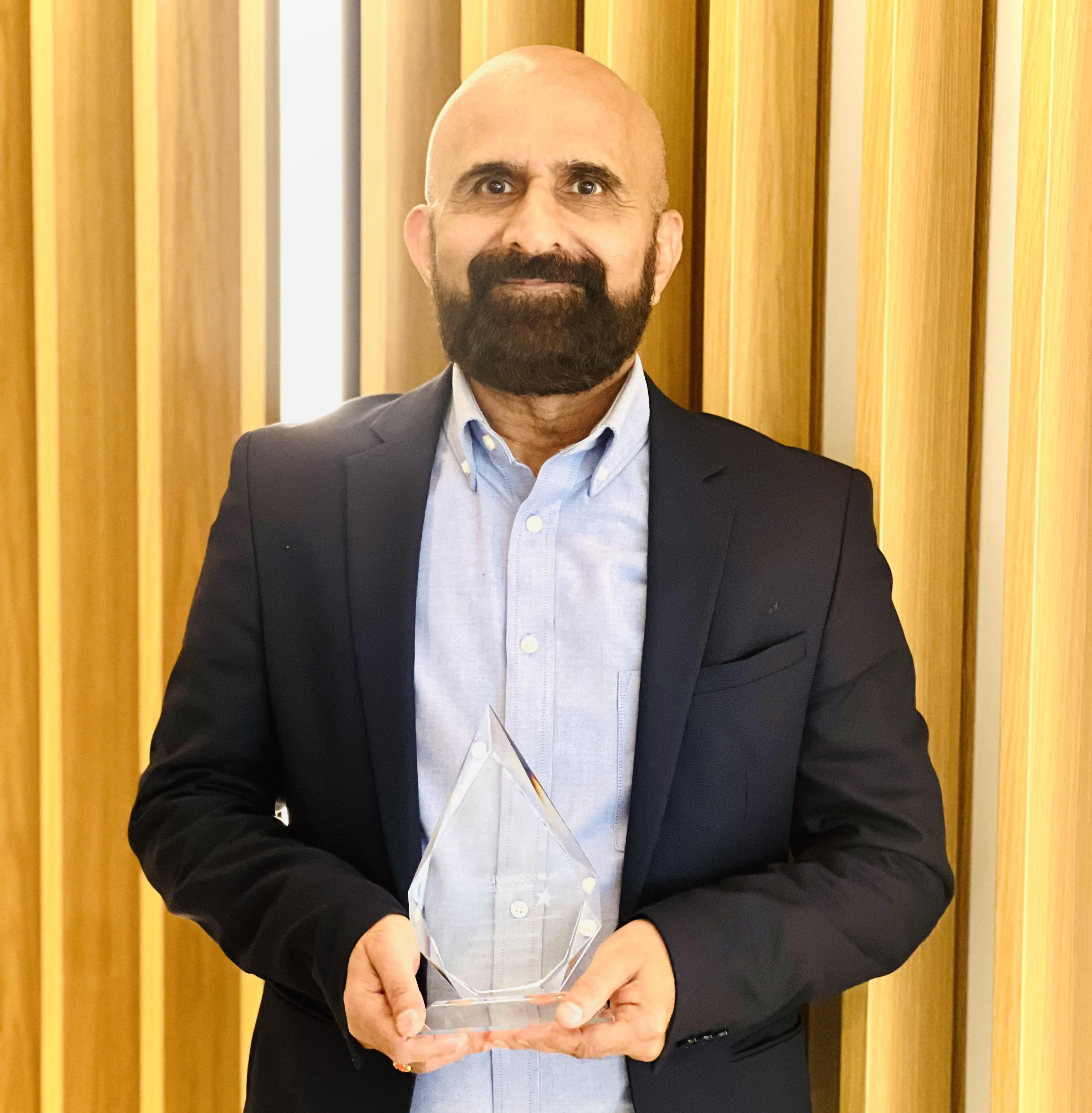 Dr. Sreekumar Menon holding an award